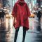 Red waterproof rain poncho with hood worn on a city street, DaRousso zero-waste design.